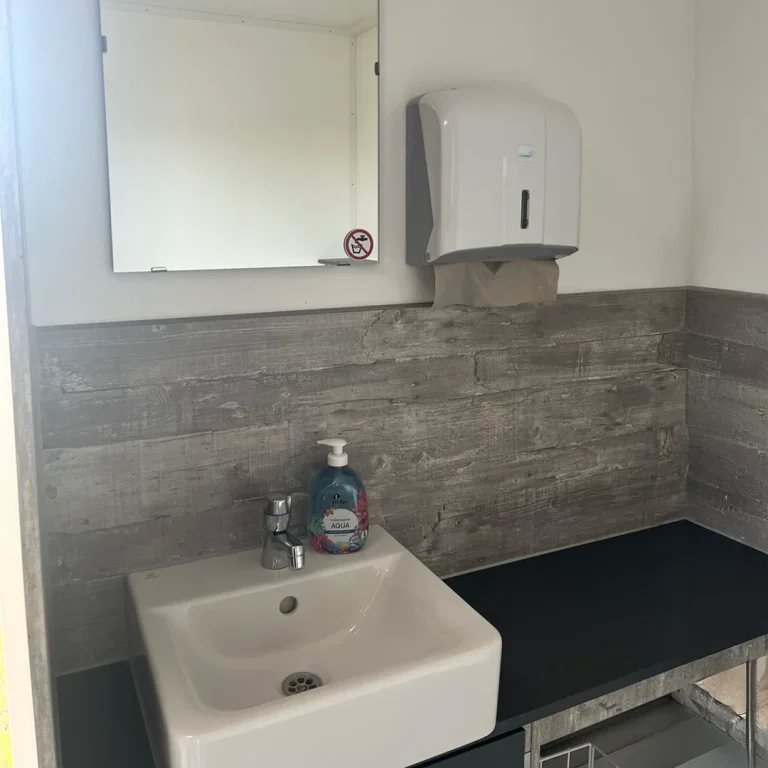 Hochwertigen Toilettenwagen mieten mit modernen Waschbecken, großen Spiegeln und schicken Armaturen.
